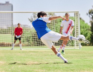 Spor, futbol ve atlet bir stadyumdaki açık hava sahasında maç veya antrenman sırasında gol atıyorlar. Futbol, fitness ve sahada antrenman yapmak için antrenman yapan sağlıklı bir adam..