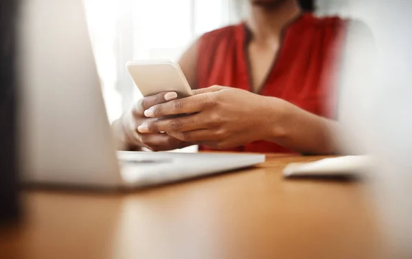发短信给客户对企业兴旺发达很重要 一个不知名的女商人在她的办公室里用手机 — 图库照片