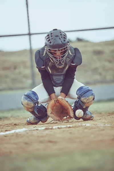 Baseball, sports and ball with a catcher on a grass pitch or field during a game or match outdoor. Fitness, exercise and catch with a male baseball player playing a competitive sport outside.