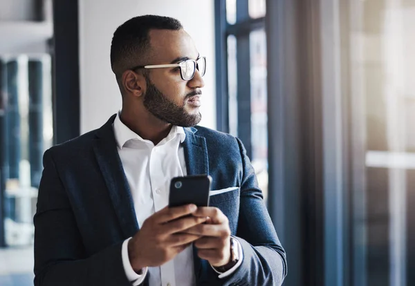 连通性对业务进展至关重要 在办公室里用手机的年轻商人 — 图库照片