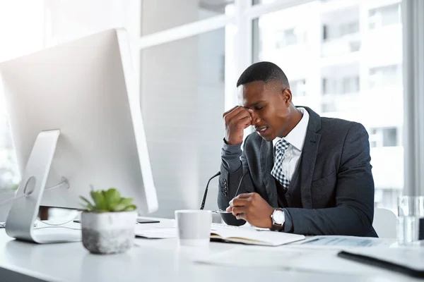 ストレスが彼の生産性を犠牲にしている 現代のオフィスで仕事をしながらストレスを感じている若いビジネスマンが — ストック写真