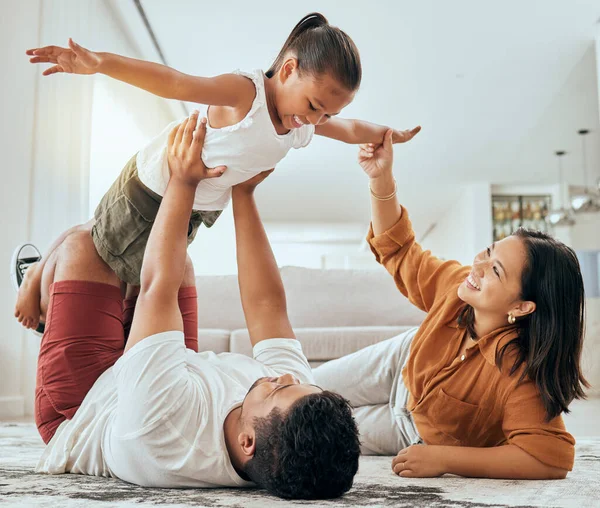 Love, floor and fun happy family play, bond and enjoy quality time together while excited and relax on ground carpet. Happiness, care and childhood relationship of mom, dad and kid girl playing games.