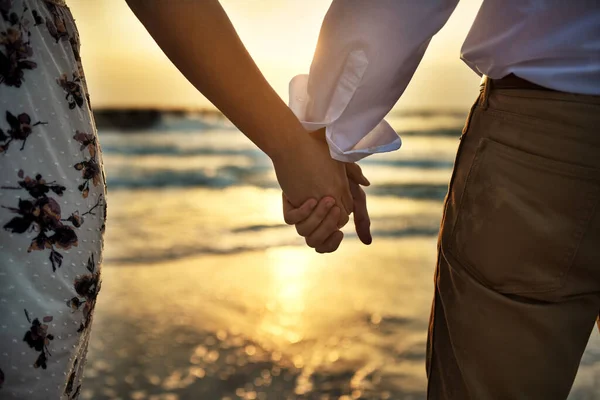 俺の手の中だ ビーチに立っている間に認識できないカップルの手を握ってのレビューショット — ストック写真