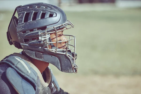 Sports, fitness and baseball catcher with helmet on diamond in stadium or park in summer sun. Game, sport and baseball player man in uniform waiting to catch ball on grass field at competition event