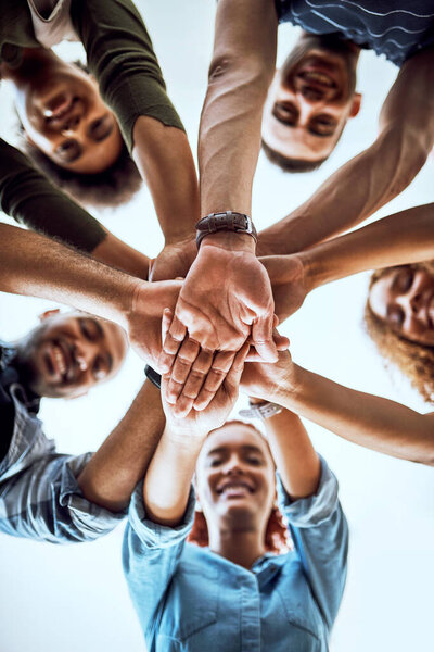 We never lack motivation. Low angle shot of a group of businesspeople joining their hands together in a huddle