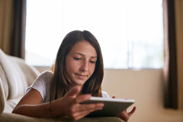 Vzdělávání Domova Soustředěná Mladá Dívka Procházení Digitálním Tabletu Zatímco Ležel — Stock fotografie