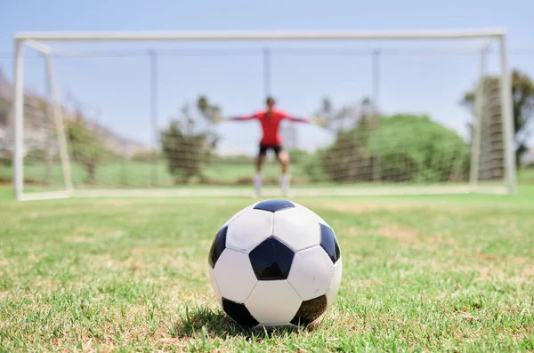 Soccer ball, football field and goalkeeper ready for defense to stop goals for penalty kick game on soccer field, grass pitch and sports stadium. Football player, goalie challenge and target training.