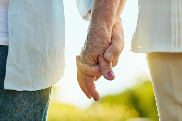 互いの手を保持し 抱擁で安全に感じる 公園で手をつないでいる老夫婦は — ストック写真