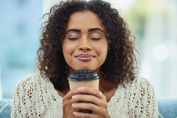 The sweet smell of coffee in the morning. an attractive young woman enjoying a cup of coffee at home