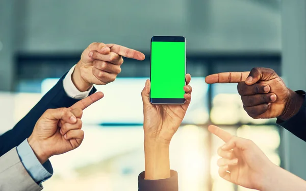 このアプリは純粋な天才です 現代のオフィスで携帯電話の緑の画面を指差しているビジネスマンのグループは — ストック写真