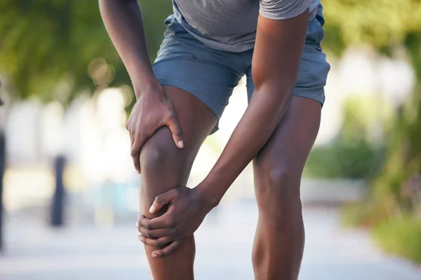 Knee pain, arthritis and legs of man runner during training, running or cardio workout in park. Muscle, leg and sport injury by athletic guy on morning run, pain and inflammation, fracture and hurt.