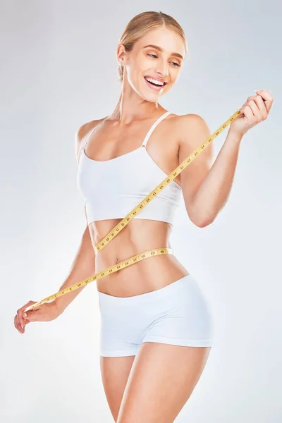 重量のための女性とテープ測定 食事と白いモックアップスタジオの背景に対するフィットネスの進行状況を確認 トレーニング後の痩せた腰で体重減少 健康と健康的な体のためのモデルの笑顔 — ストック写真