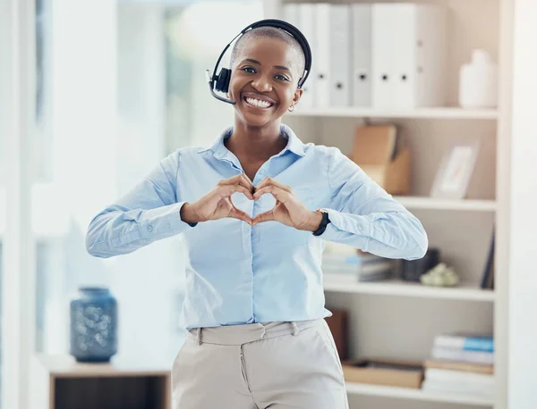 Hand, heart and call center consultant in office showing love, trust and hope while working in crm management. Black woman, hands and thank you while consulting for customer service with excellence.