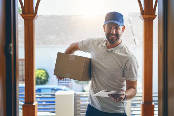 Delivery man reporting for duty. Portrait of a courier making a home delivery