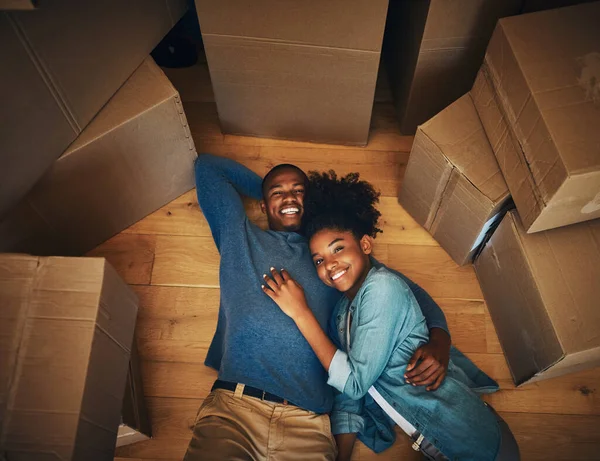 该是刹车的时候了 一对快乐的年轻夫妇在搬家的当天躺在地板上 被纸板箱围住的画像 — 图库照片