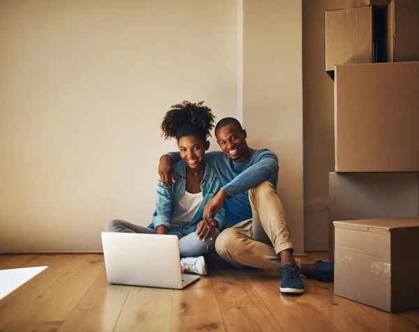 看看我们能买的东西 一对快乐的年轻夫妇在家里被纸盒包围时一起在笔记本电脑上浏览的肖像 — 图库照片