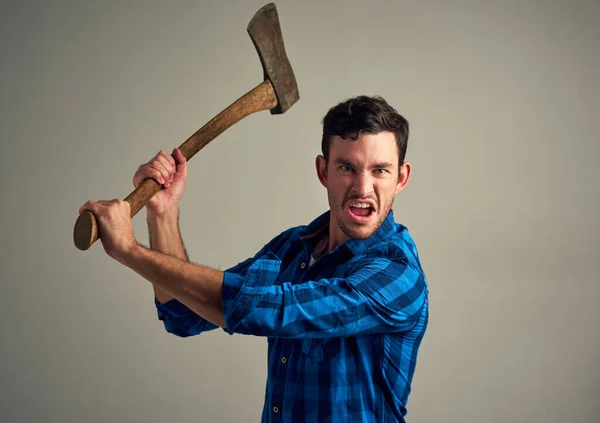 砍倒什么东西需要力气 工作室拍摄的一个年轻的男性伐木工拿着斧头在灰色背景下 — 图库照片
