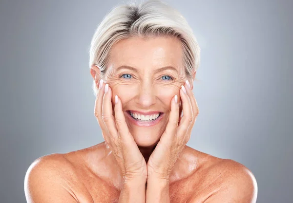 Portrait, senior woman and beauty, skincare and wellness in studio for grooming, hygiene and pamper routine on grey background. Face, elderly model and happy, smile and excited about facial treatment.