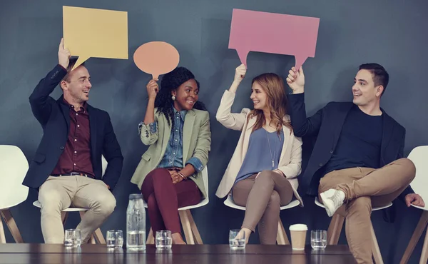 stock image Speak your mind if you have business on it. a group of businesspeople holding up speech bubbles while waiting in line for an interview