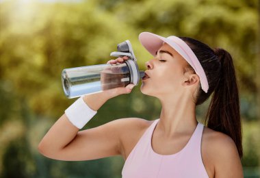 Tenis maçında molada su içen bir kadın, yazın antrenman ya da hidrasyon için egzersiz. Tenisçi kız, spor müsabakalarında sağlık, sağlık ve su için sıvı iç..