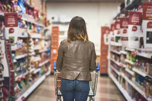 食料品の買い物が進行中です 食料品店で買い物中の若い女性のレビューショット — ストック写真