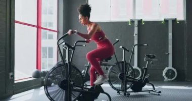 Egzersiz bisikleti, kardiyo ve kız bisikleti spor fitness, atlet maratonu antrenmanı ya da yüksek enerji vücut egzersizi. Spor salonu performansı motivasyonu, sağlık anlayışı ve bisiklet süren siyah kadın..