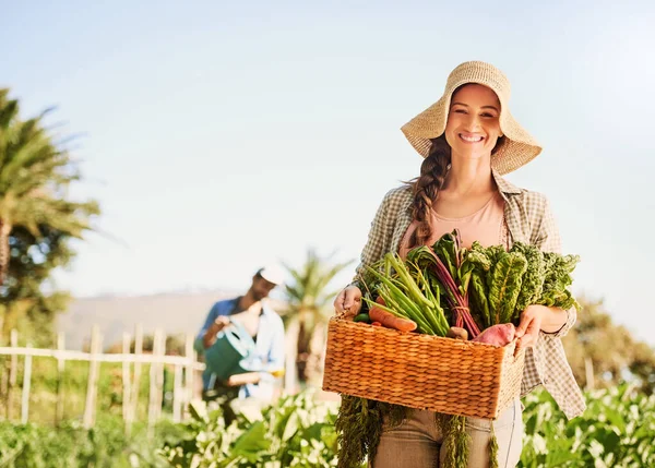 我们为我们的产品感到自豪 一个快乐的年轻农民在自家农场的篮子里采摘香草和蔬菜的画像 — 图库照片