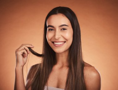 Kahverengi stüdyo arka planında izole edilmiş güzel bir portre, cilt bakımı ve saç bakımı. Avustralya 'dan sağlıklı, uzun ve güzel ipek saçlı mutlu kadın modelin sağlığı, makyajı ve gülümsemesi.