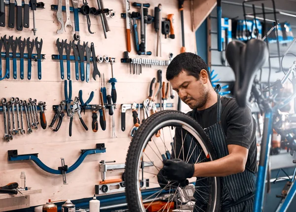 他知道自行车需要什么 在自行车修理店工作的人 — 图库照片