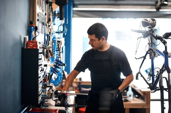 The best man for a bicycle repair job. a man working in a bicycle repair shop