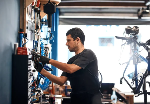 他对修理自行车没什么不知道的 在自行车修理店工作的人 — 图库照片
