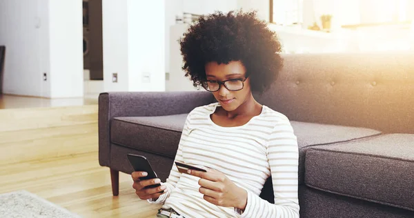 stock image So many payments to make today. a focused young woman seated on the floor while doing online shopping on her computer in the living room at home