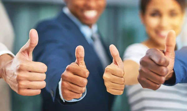 stock image Consider this our official stamp of approval. a group of businesspeople giving thumbs up in a modern office