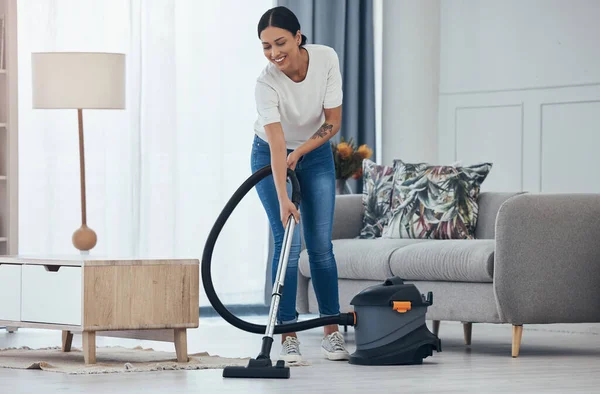 Black woman vacuum cleaner, smile in living room and cleaning tiles floor in home for hygiene. Woman cleaner, happy with appliance for housekeeping work on flooring in house for dust or dirt indoors.