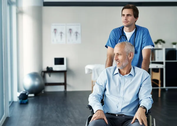 Getting his health back on track. a male nurse caring for a senior patient in a wheelchair
