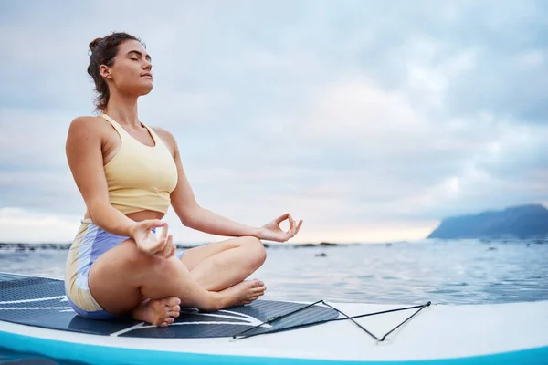 サーフィンや海の女性とサーフボードの自然の中で雲とモックアップで浮動小数点の上に 海と外の健康 ウェルネスやバランスのための若い女性瞑想と禅 — ストック写真