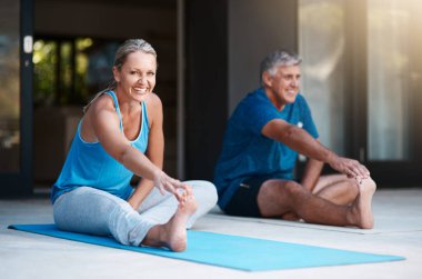 Esneme egzersizi yaparken gereksiz yaralanmaları önler. Olgun ve mutlu bir çift, yoga seanslarına başlamadan önce evlerinin önünde esniyorlar.