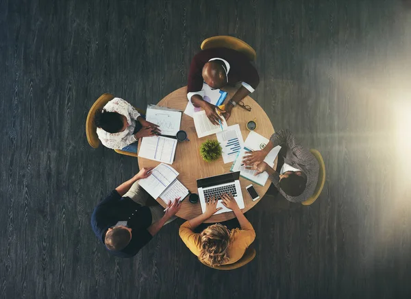 How the top workers get it done. High angle shot of a group of businesspeople having a meeting in a modern office