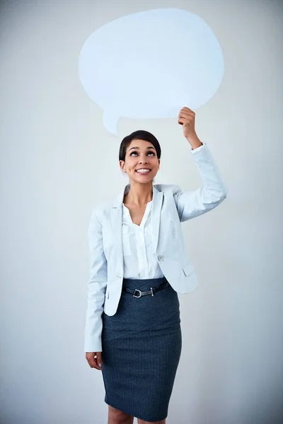 stock image Are you thinking about business ideas, place it here. Studio shot of an attractive corporate businesswoman holding up a speech bubble against a gray background