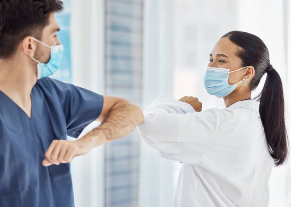 Doctors, elbow greeting and covid safety in social distancing, compliance or regulations at the hospital. Medical professionals greet with arms for health and safety during pandemic at the workplace.