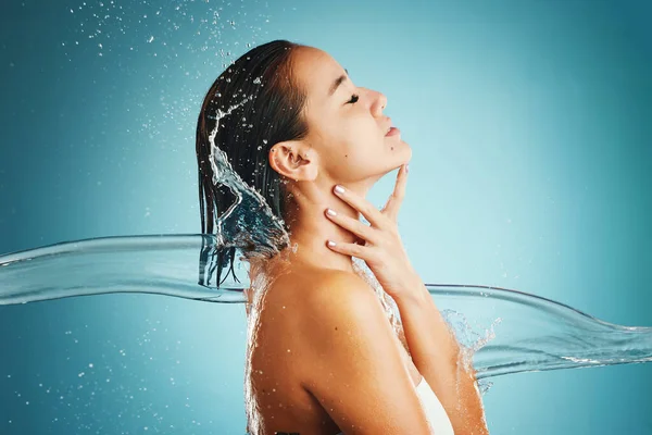 スプラッシュ 水と体の世話をする女性は 洗浄し 青のモックアップスタジオの背景に対してシャワーで 健康と美しさのために肌をきれいにする天然液体とスパ 健康とアジアモデル — ストック写真