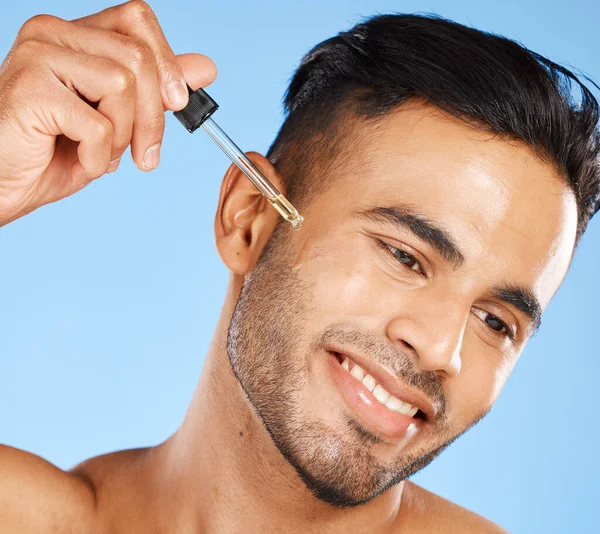 护肤和男人血清的脸与蓝色工作室背景 年轻的模特儿 配以含有透明质酸的液体 促进胡须生长 清洁和皮肤科健康 — 图库照片