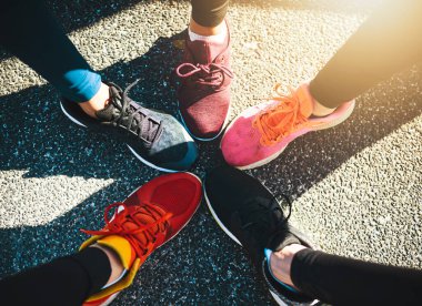 Our shoes fit our personalities. a group of unrecognizable peoples runnings shoes put next to each other in a circle outside during the day clipart