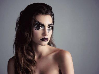 Size up your eyes. Studio shot of an attractive young woman wearing bold makeup clipart