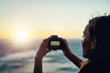 Bu mükemmel bir manzara. Genç bir kadının dışarıda fotoğraf çekerken çekilmiş dikiz görüntüsü.