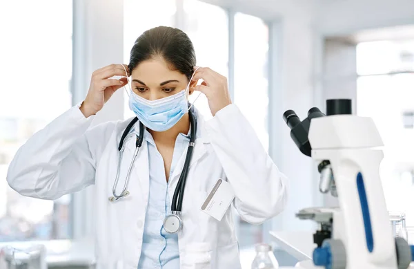 化验室的工作人员穿上正确的防护服是很重要的 在实验室工作时戴上外科口罩的年轻科学家 — 图库照片