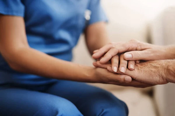 stock image Im here to help. an unrecognizable nurse holding a senior womans hands in comfort