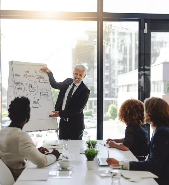 stock image Outlining the focus of their plans. a businessman giving a presentation to his colleagues in a boardtoom