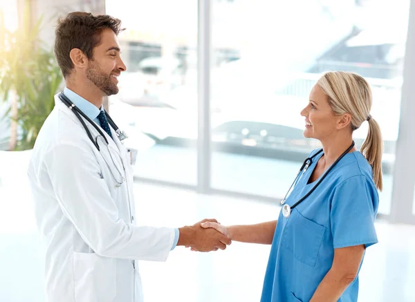 君なしではできなかった 2人の医療従事者が病院のホワイエで握手をし — ストック写真
