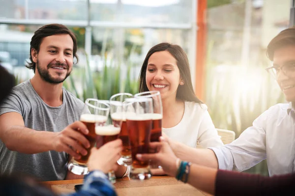 stock image Its been a real year guys. a group of young business colleagues having a celebratory toast with beer around a table outside